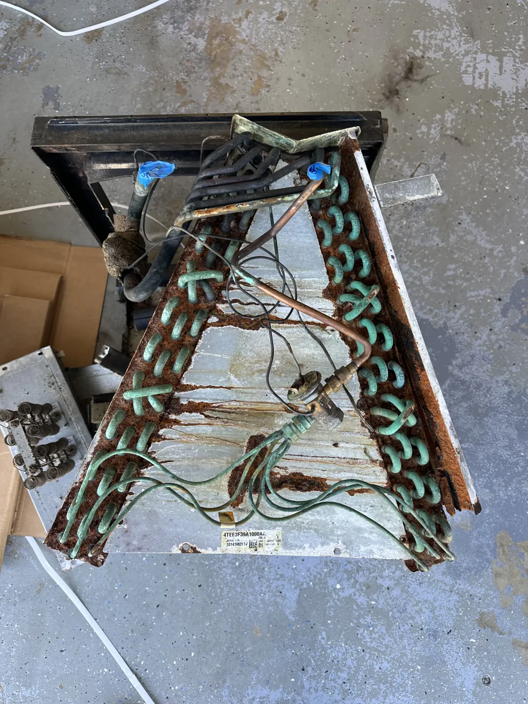 An aged evaporator coil out of its cabinet, fins and tubing corroded