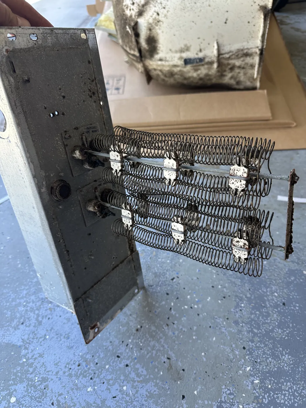 A rack of electric heat-strip elements removed from an air handler, resistance coils visible