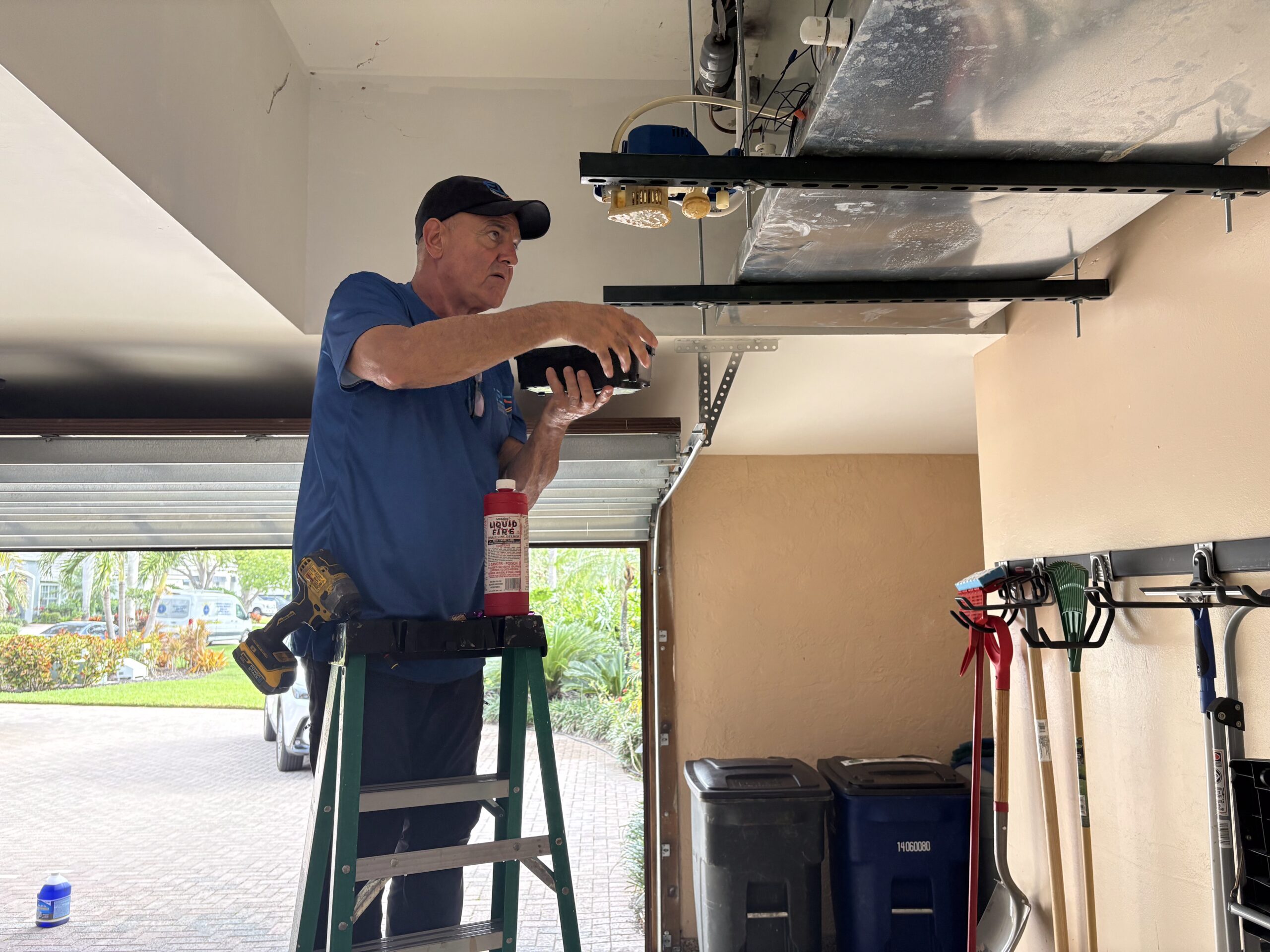 ECS HVAC technician on ladder servicing air handler Cape Coral FL — Exclusive Cooling Solutions